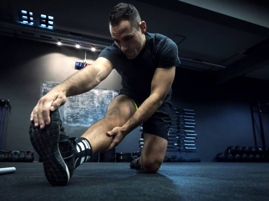 ragazzo che gioca a padel fa stretching per recuperare post partita