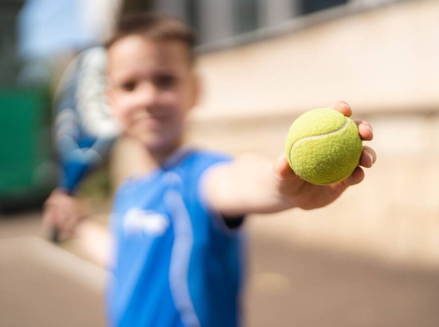 bambino a lezione padel tiene pallina in mano