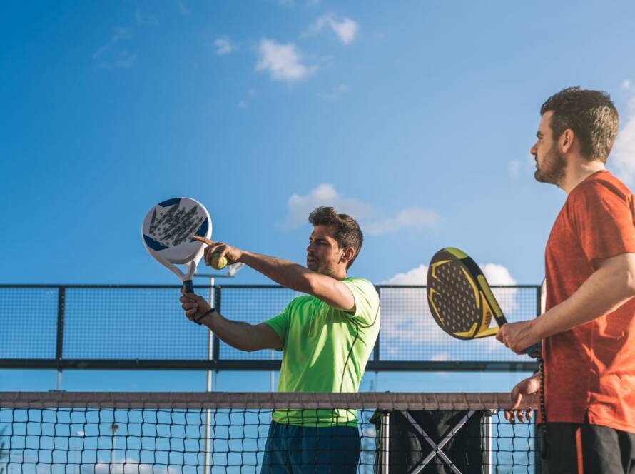 maestro di padel insegna volee ad alunno