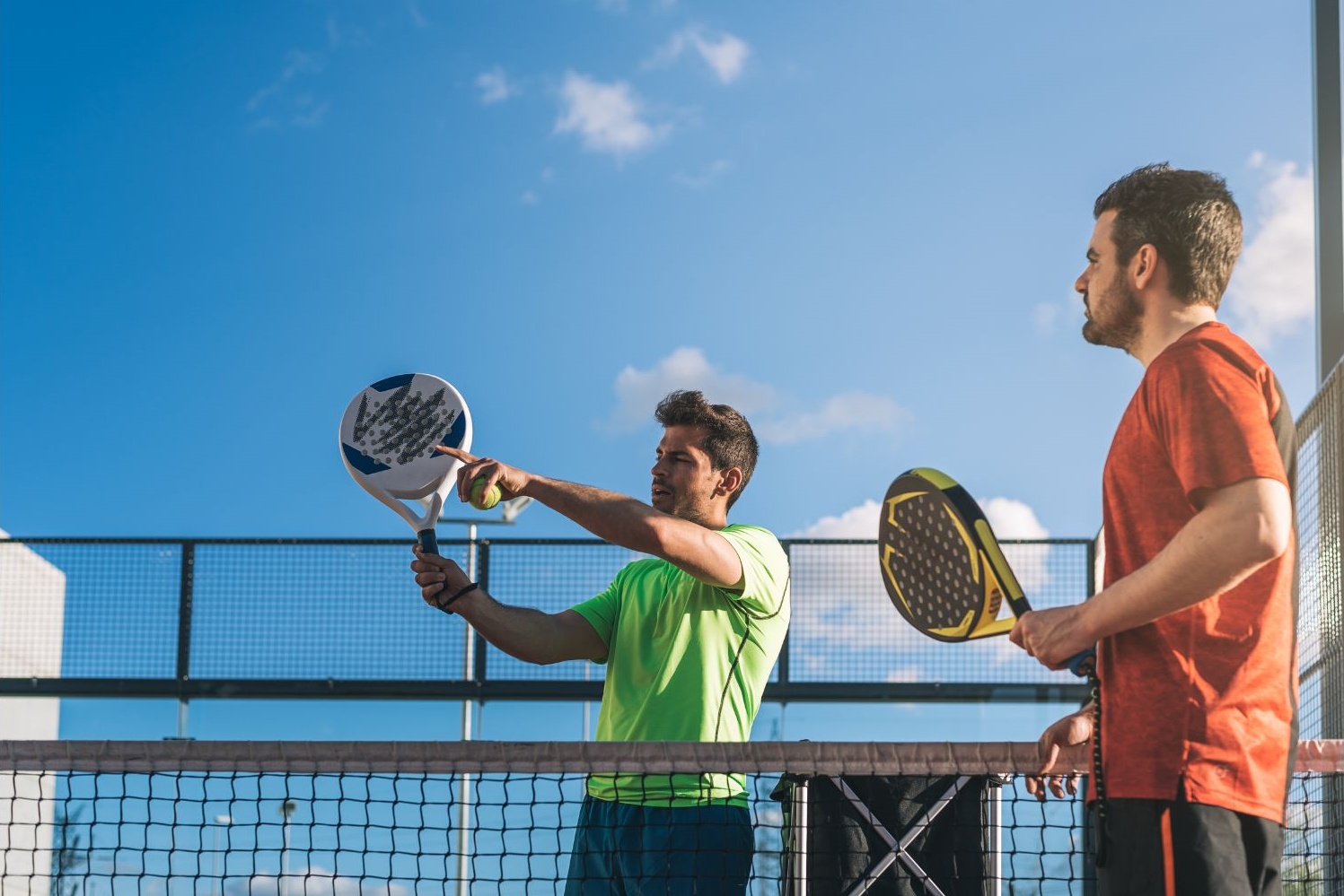 maestro di padel insegna volee ad alunno