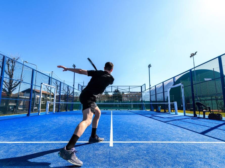 ragazzo effettua backspin a fondo campo a padel